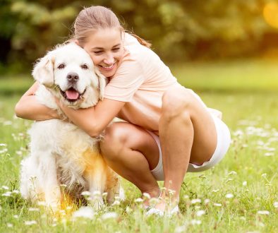 Woman hugs Golden Retriever dog