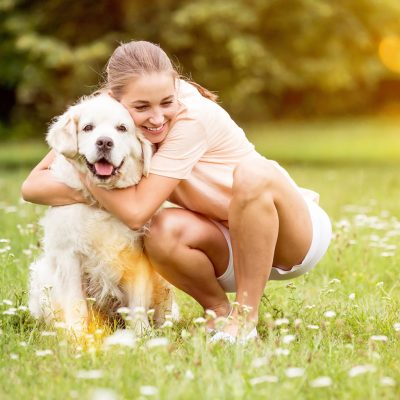 Woman hugs Golden Retriever dog